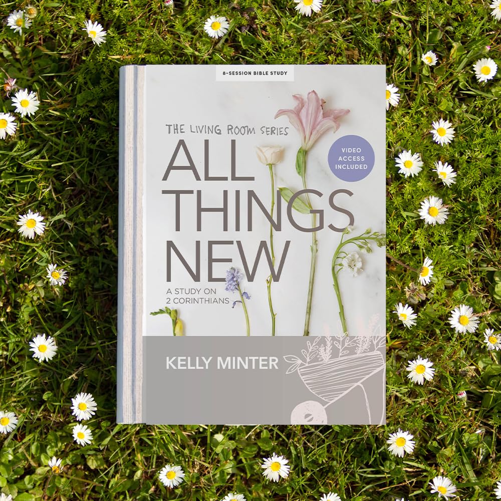 A book titled 'All Things New: A Study on 2 Corinthians' by Kelly Minter, placed on a grassy surface with white daisies. The book is part of 'The Living Room Series' and indicates 'Video Access Included'.